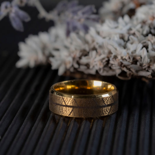 Close-up of the laser engraved leaf skeleton texture on the gold tone ring.