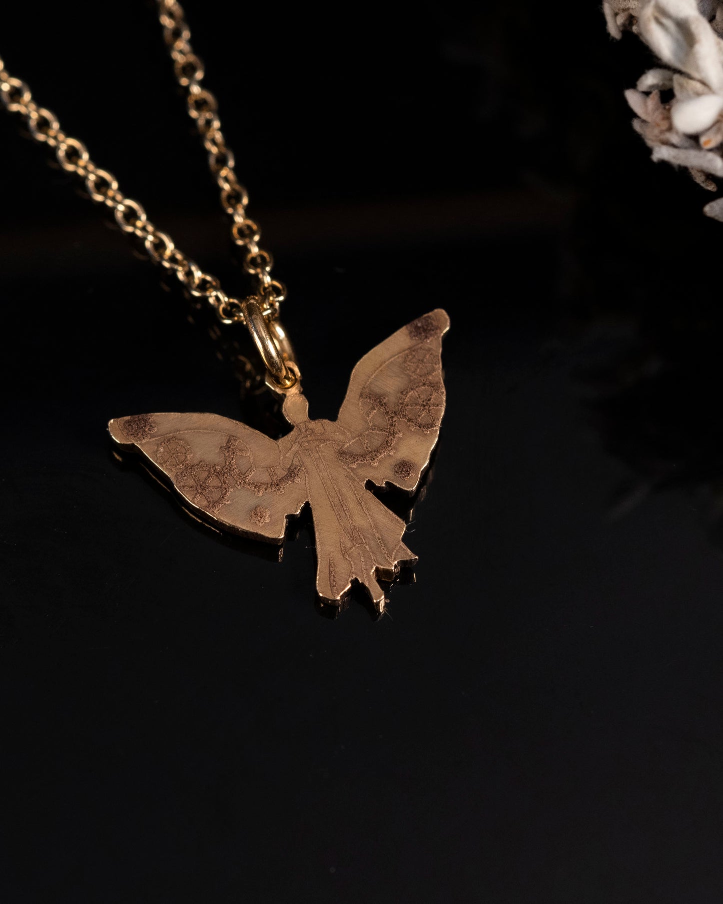 Close-up of the laser engraved details on the brass Clockwork Angel pendant
