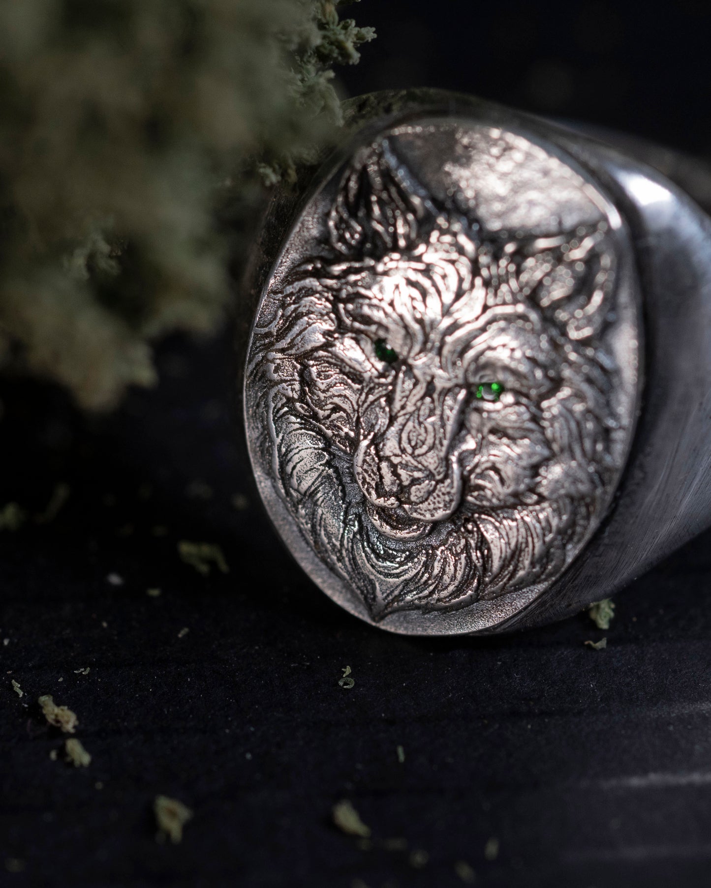 "Close-up of the green Cubic Zirconia eyes on the silver Wolfe family shield signet ring