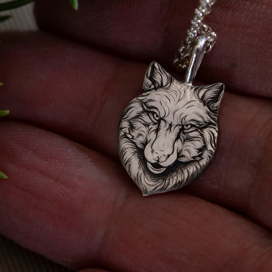 Detail in hand of the small version of the Wolfe Family Shield pendant