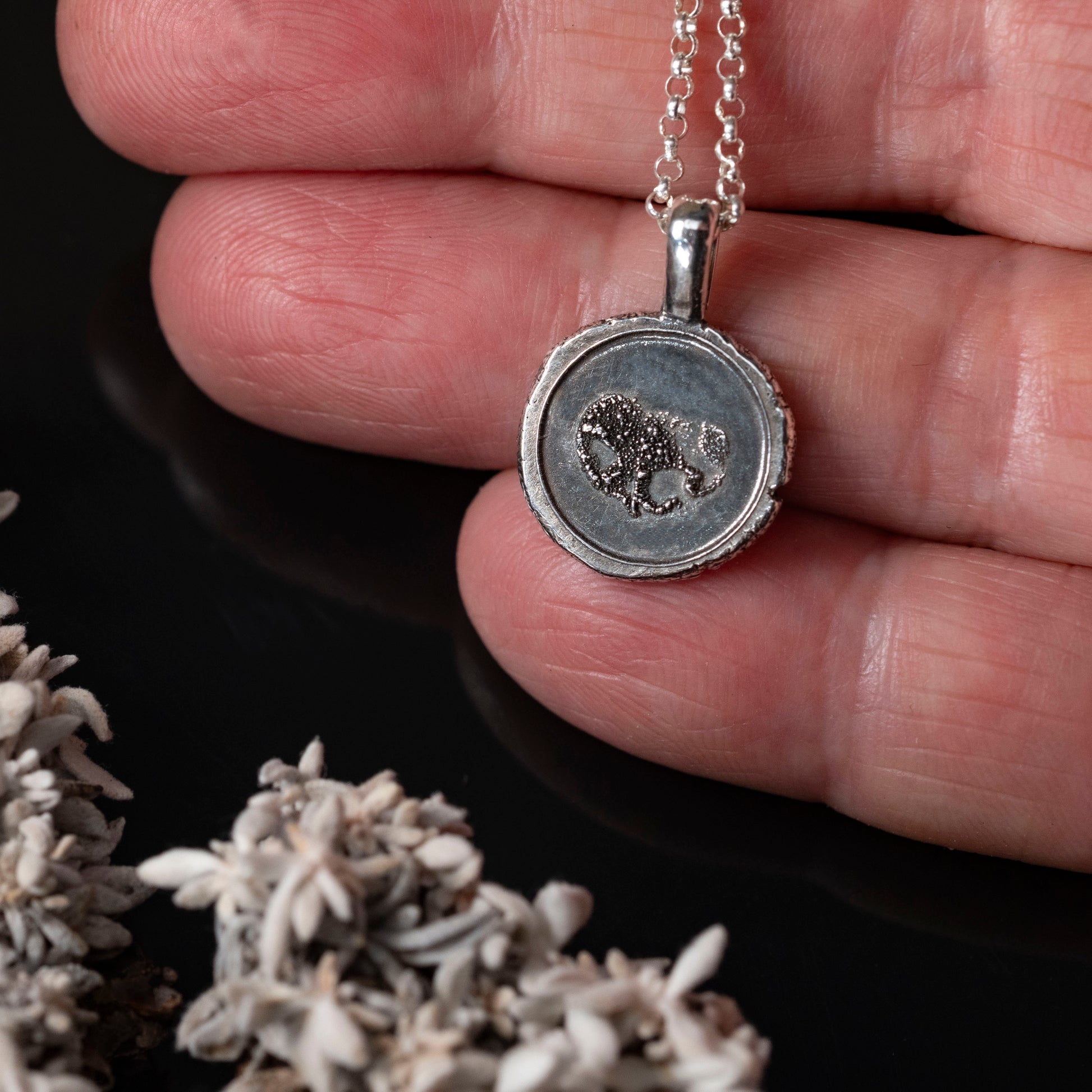 details of silver pendant with dog nose imprint 