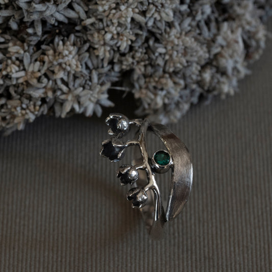 May Lily of the Valley wrap ring in sterling silver with a 3mm lab-created emerald, hand-fabricated botanical jewelry by Hebel Design.