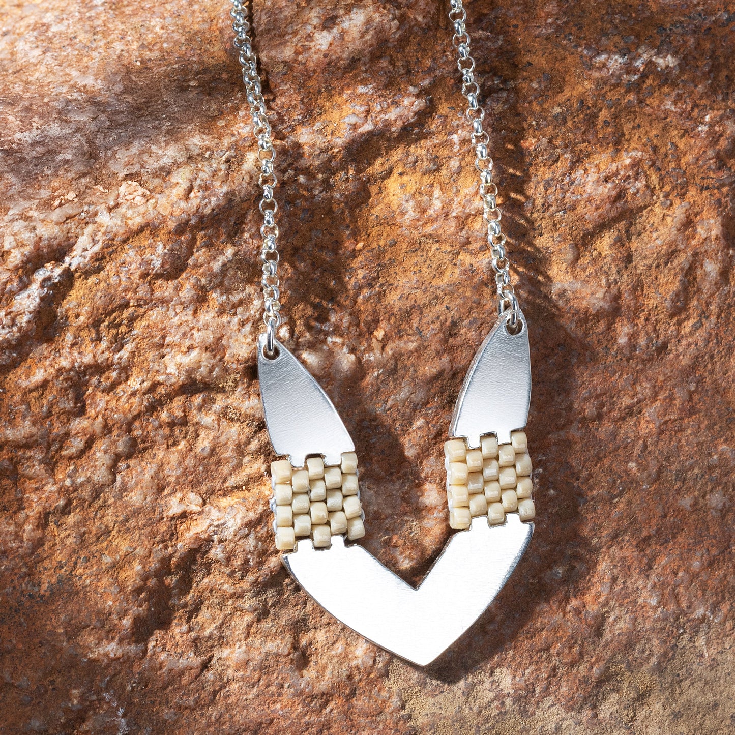 Necklace with a unique pendant on a textured stone surface