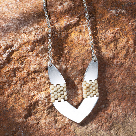 Necklace with a unique pendant on a textured stone surface