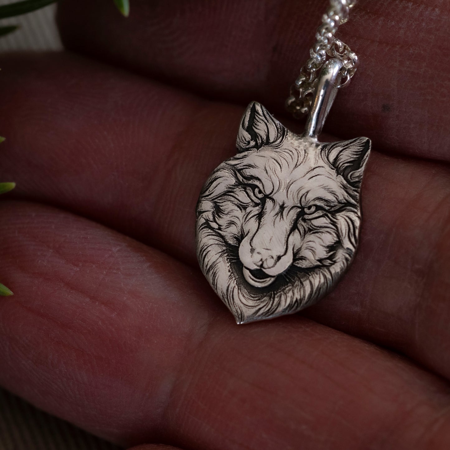Detail in hand of the small version of the Wolfe Family Shield pendant