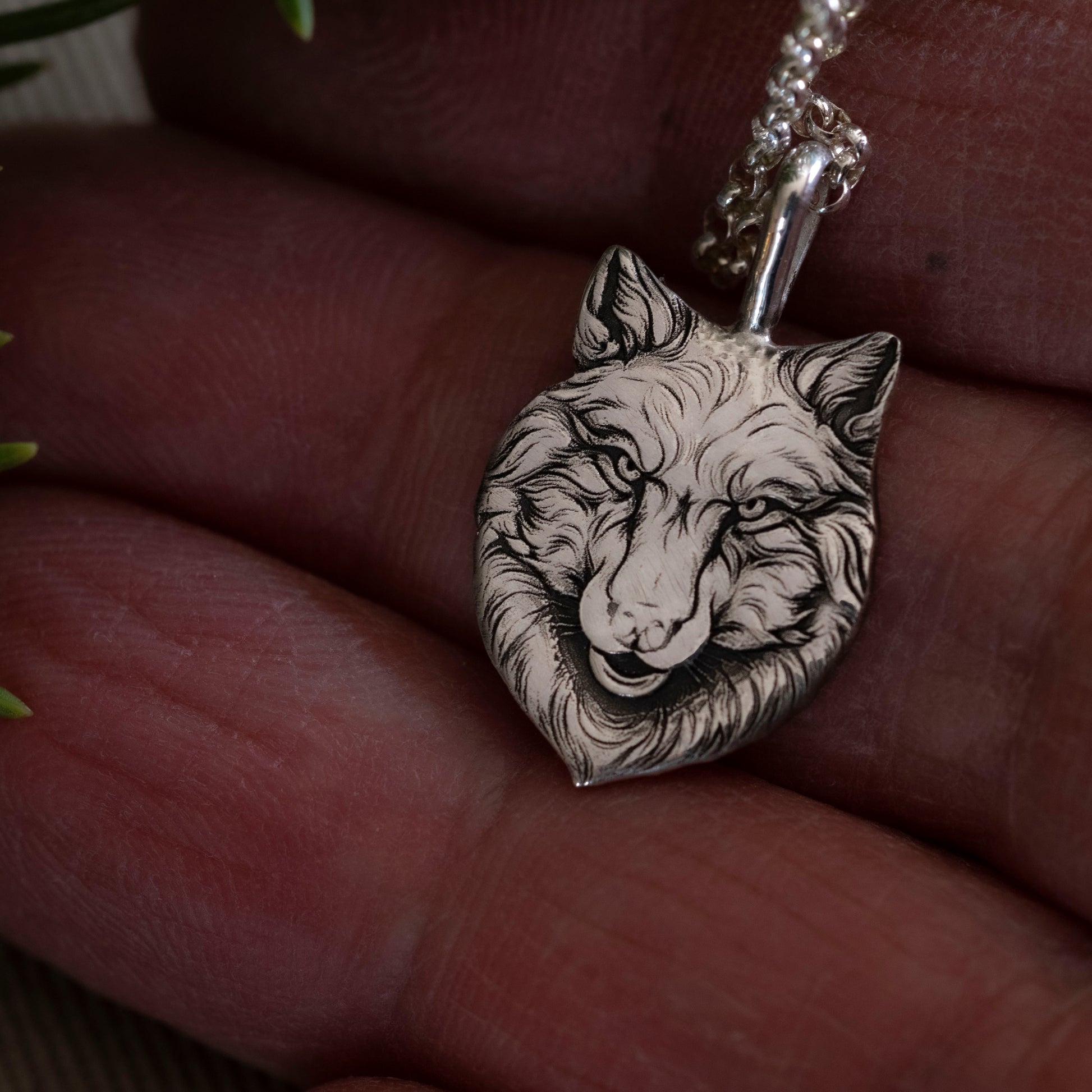 Detail in hand of the small version of the Wolfe Family Shield pendant